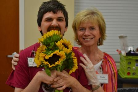 Josh peeks behind the sunflowers w